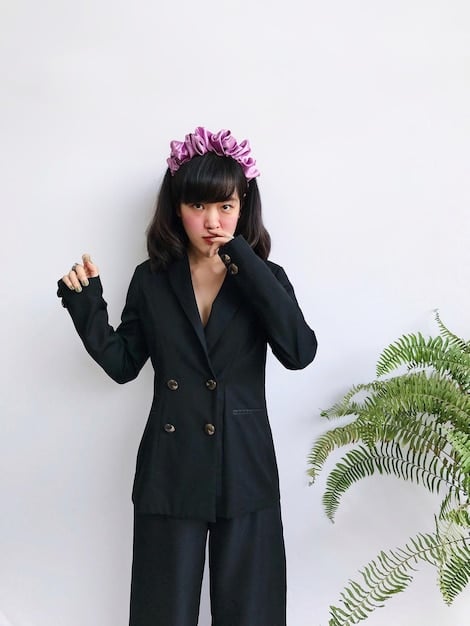 Ryujin, a member of ITZY, posing in a stylish, oversized blazer with vibrant colors and bold patterns. The background is a minimalist studio setting, highlighting the outfit's details and the overall aesthetic.