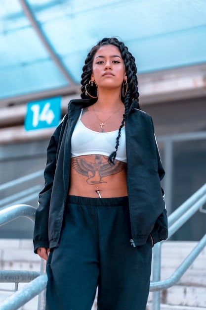 Yuna from ITZY wearing a sporty chic outfit with a crop top, high-waisted track pants, and stylish sneakers. The setting is a modern cityscape, emphasizing the urban and trendy vibe of her look.