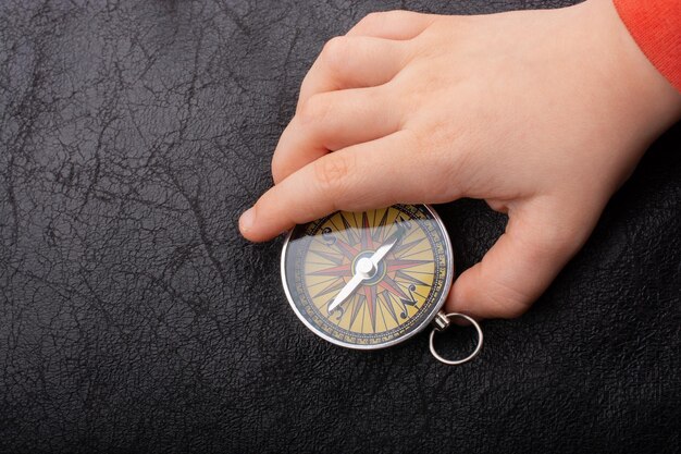 A close-up photograph of a compass prop used in one of ATEEZ's music videos, highlighting the intricate details and the overall pirate theme. The compass is set against a backdrop of aged parchment, adding to the visual depth.