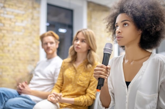 A behind-the-scenes shot of a J-Pop group being interviewed by an American journalist. The members appear relaxed and confident as they answer questions in English.
