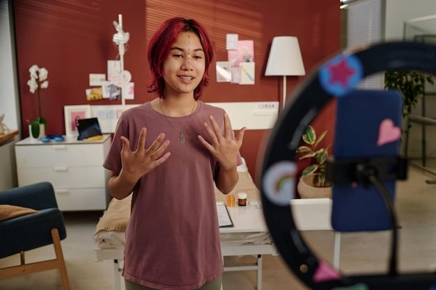A content creator in their home studio, actively responding to comments on their K-Pop reaction video using a laptop. The screen shows various comments and the creator is smiling as they type a response.