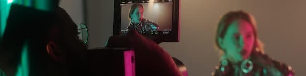 A director reviewing footage on a monitor, surrounded by crew members in a dark, high-tech studio. Smoke machines add atmosphere, and a J-Pop idol is visible in the background rehearsing a dance move.